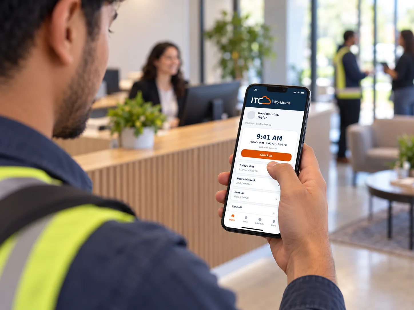 Employee clocking in with the ITC Workforce app in a modern office